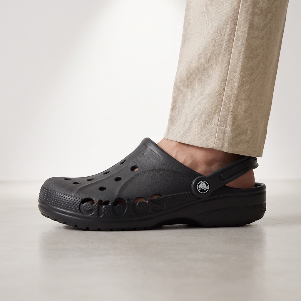Claquette LAS ROSAS Baya noire en mousse souple avec ouvertures latérales, portée avec un pantalon beige.