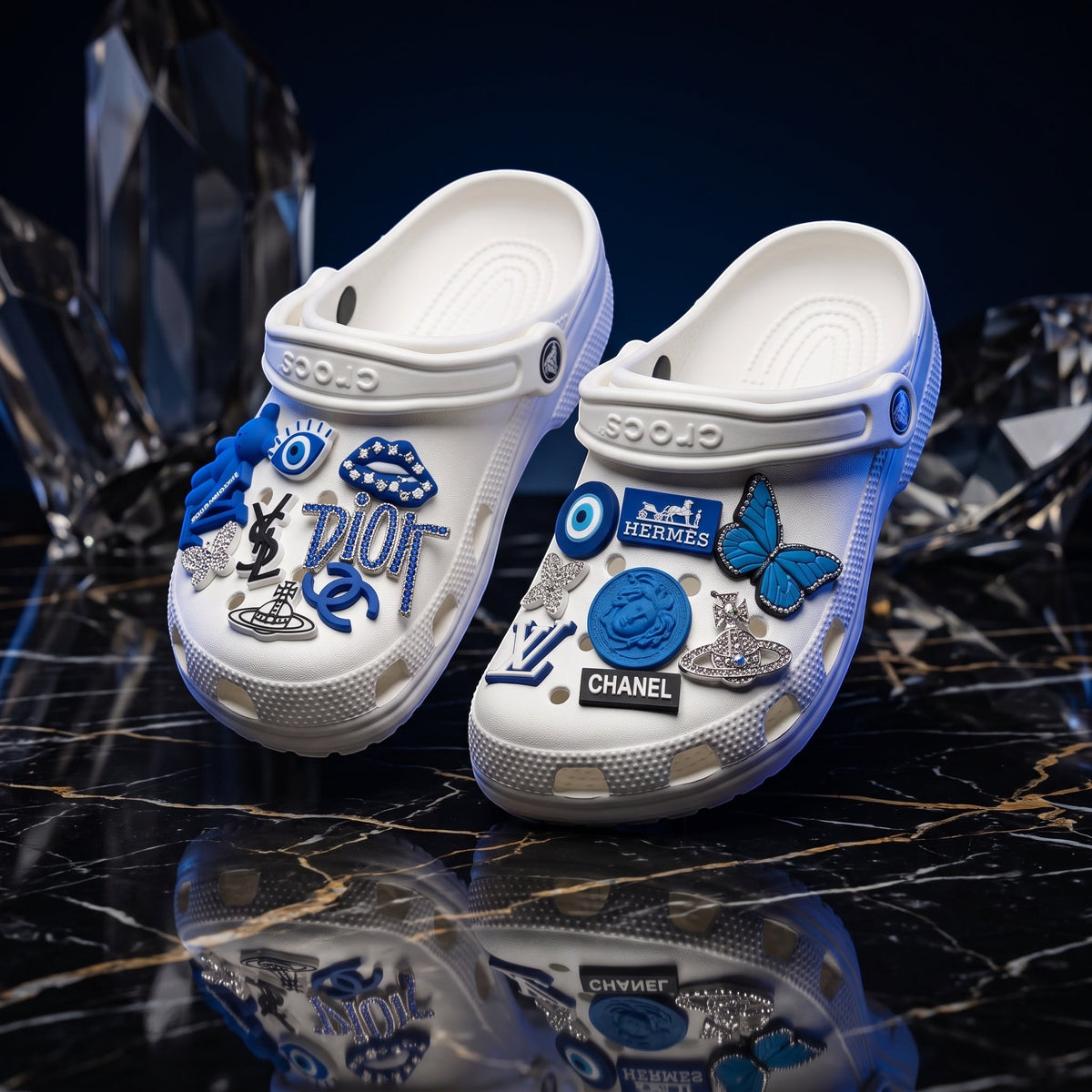 Sabots blancs LAS ROSAS personnalisés avec des charms bleus et argentés sur un fond noir brillant